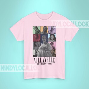 May include: Pink t-shirt with a collage of images of a woman in a white dress and other people. The text "Villanelle The Eras Tour" is printed on the shirt.