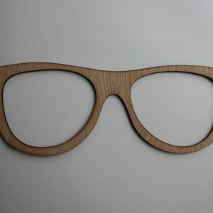 Puede incluir: Corte de marco de gafas de madera, un material artesanal para hacer una decoración de pared o un regalo único.