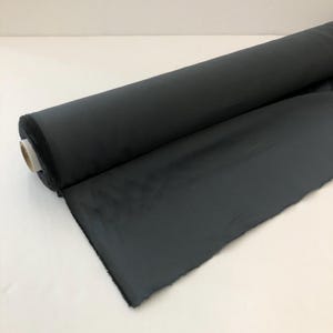 May include: A roll of dark grey fabric, likely for sewing or crafting projects.