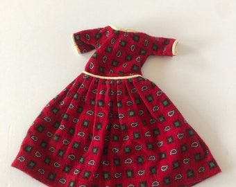 May include: A red dress with a paisley pattern and a white trim around the neckline and waist. The dress has short sleeves and a full skirt.