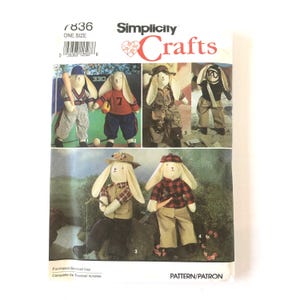 May include: Simplicity Crafts pattern 7836 for stuffed rabbit dolls. The envelope displays six variations of rabbits dressed in different outfits, including baseball gear, camouflage, aviator attire, fishing gear, and a red plaid flannel shirt.