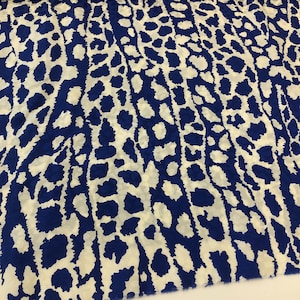 May include: White fabric with a blue leopard print pattern.