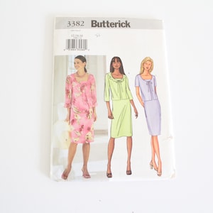 May include: A sewing pattern envelope with the number 3382 and the word "Butterick" printed on the front. The envelope shows three women wearing different dresses and skirts. The dresses are pink with floral print, green, and purple.