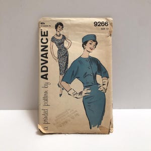 May include: Vintage Advance sewing pattern, size 13, featuring illustrations of two women in dresses. The pattern cover is tan with teal and black illustrations. The text "Advance" and "a printed pattern by" are visible.