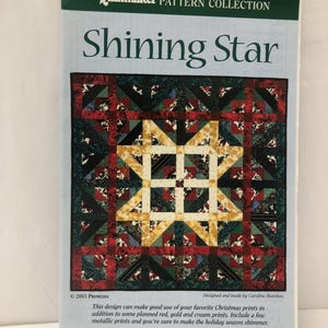 May include: A pattern collection titled "Shining Star" featuring a quilt design with a central star motif. The quilt design incorporates red, green, gold, and cream-colored fabrics. The text on the cover reads "The Quiltmaker Pattern Collection."