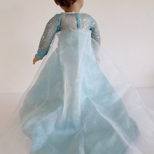 May include: A light blue dress with a sheer overlay. The dress has a sparkly bodice and a flowing skirt.