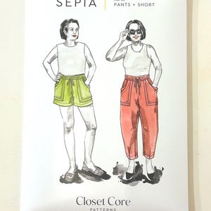 May include: A white paper package with the word "SEPIA" and "No. 41 PANTS + SHORT" printed in black. The package features illustrations of two women wearing shorts and pants. The brand name "Closet Core PATTERNS" is printed at the bottom.