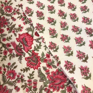 Puede incluir: Una tela blanca con un patrón floral rosa y verde. La tela tiene un patrón repetitivo de flores y hojas.