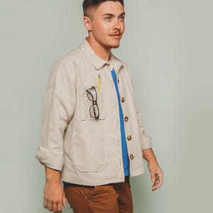 May include: A light beige Ilford Jacket with a blue shirt underneath, brown pants, and a pencil and glasses in the pocket. The text on the image says "#024 confident beginner for woven fabrics XS - 7X" and "FRIDAY pattern co."