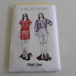 May include: A sewing pattern for a top and dress called "Cielo" from Closet Case Patterns. The pattern shows two women wearing the garment, one in a red dress and the other in a purple top and white shorts.