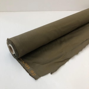 Peut inclure: Un rouleau de tissu vert olive avec le texte "1234 AF" imprimé sur le côté.