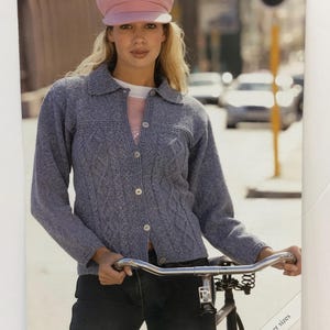 May include: A knitting pattern for a blue denim cardigan with a cable knit design. The pattern is from Sirdar and is for sizes 32-34 inches. The pattern number is 8445.