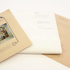 May include: A brown paper pattern with a picture of a quilt with a variety of colorful animal and geometric shapes. The text "Patchwork Pieces" and "Milo's Toys" is printed on the paper.