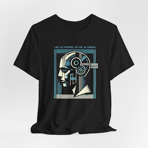 Op de afbeelding: Zwart T-shirt met een afbeelding van een gestileerd mensenhoofd met geometrische patronen en de tekst "Ik ben misschien paranoïde, maar geen android."