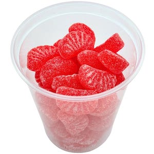 May include: A clear plastic cup filled with red, sugar-coated gummy candies shaped like orange slices.
