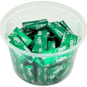 May include: A clear plastic container filled with individually wrapped Andes mints. The mints are green and have the Andes logo printed on them.