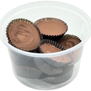 May include: A clear plastic container filled with chocolate peanut butter cups. The cups are arranged in a random pattern and are all the same size and shape.
