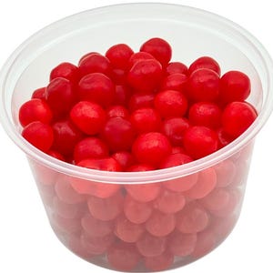 May include: A clear plastic container filled with bright red, round candies. The candies are densely packed, with a glossy appearance. The container is transparent, allowing the candies to be fully visible. The background is plain white.