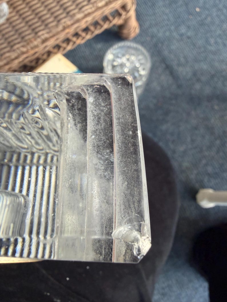 K&ouml;nnte beinhalten: Ein klarer, rechteckiger Glasgegenstand mit vertikalen Linien und einer strukturierten Oberfl&auml;che. Der Gegenstand hat eine abgebrochene Ecke und scheint Teil eines gr&ouml;&szlig;eren St&uuml;cks zu sein. Das Glas ist leicht tr&uuml;b.