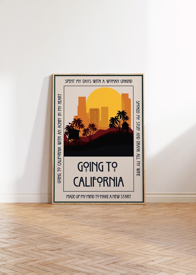 May include: A framed art print with a retro design. The artwork features a sunset over a silhouette of palm trees and buildings. The words "Going to California" are prominently displayed, with additional text around the border.
