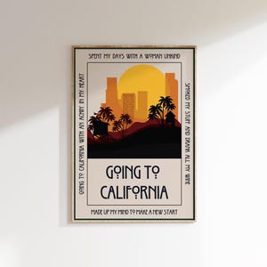 May include: A framed art print with a retro design. The artwork features a sunset over a city skyline with palm trees. The text "Going to California" is prominently displayed, along with other phrases.