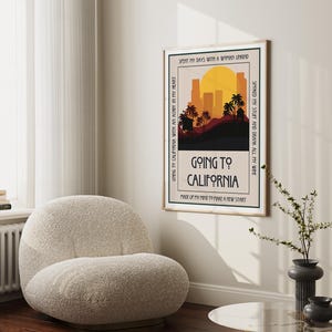May include: A framed art print with a retro design featuring a California landscape with palm trees, a sunset, and the text "Going to California." The print has a beige background and a black border. The text includes the phrases "Spent my days with a woman unkind" and "Made up my mind to make a new start."