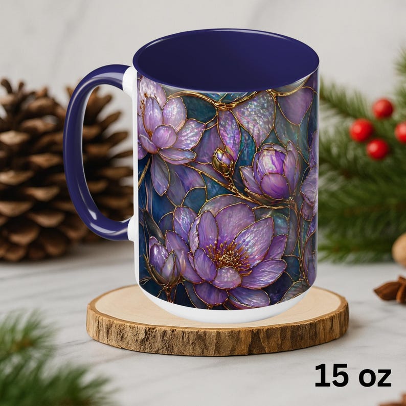 May include: A 15 oz ceramic mug with a floral design. The mug features a navy blue interior and handle, with a white base. The exterior showcases a detailed illustration of purple lotus flowers with gold accents against a dark blue background.