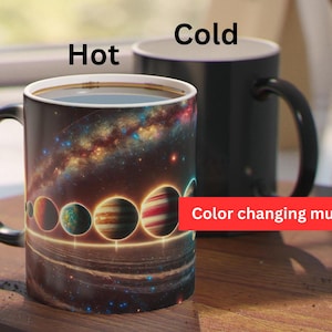 May include: A color-changing mug with a black exterior and a space-themed design. The mug features a depiction of a galaxy with planets and stars. The text "Hot" and "Cold" are printed on the mug, indicating its temperature-sensitive nature. The mug reads "Color changing mug" on the bottom.