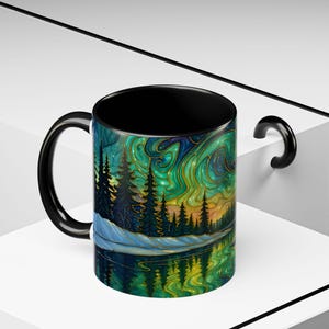 May include: A black-handled coffee mug with a vibrant landscape design. The artwork features a forest, lake, and swirling aurora borealis in shades of green, blue, and gold. The interior of the mug is black.