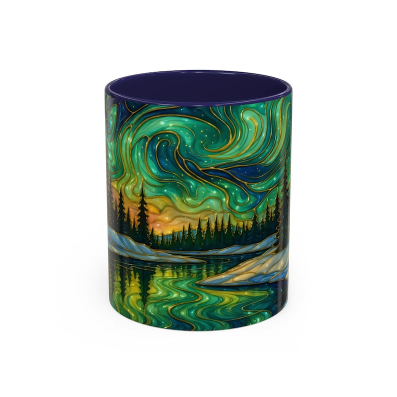 May include: A ceramic coffee mug with a vibrant illustration of the Northern Lights. The design features swirling green and gold colors, a forest silhouette, and a reflective lake. The interior of the mug is a deep blue.