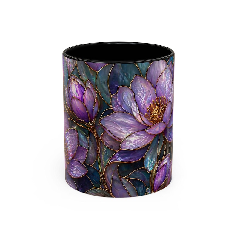 May include: A ceramic mug featuring a stained-glass floral design. The design showcases purple flowers with gold outlines against a dark teal background. The interior of the mug is black.