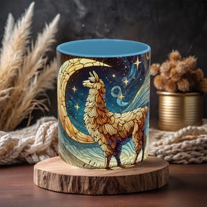 May include: A blue and white ceramic mug with a llama standing in front of a crescent moon and stars. The llama is brown and white and has a long neck and fluffy fur. The background is a dark blue with white stars.