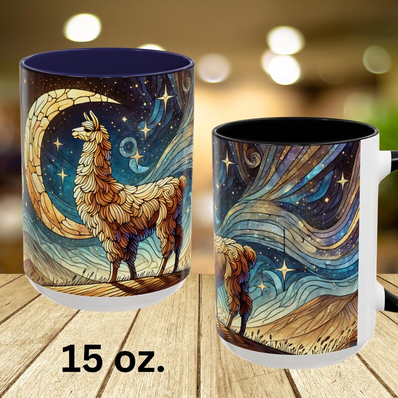 May include: A white ceramic mug with a black interior and a colorful illustration of a llama standing in front of a crescent moon and stars. The mug is 15 ounces.