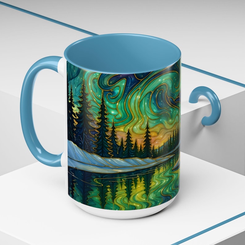 May include: A ceramic coffee mug with a vibrant landscape design. The mug features a blue interior and handle, and a wraparound image of a forest scene with a lake reflecting the aurora borealis in shades of green, gold, and blue.