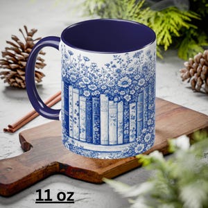 May include: White ceramic mug with a blue floral and book design. The interior and handle are navy blue. The mug has a capacity of 11 oz.