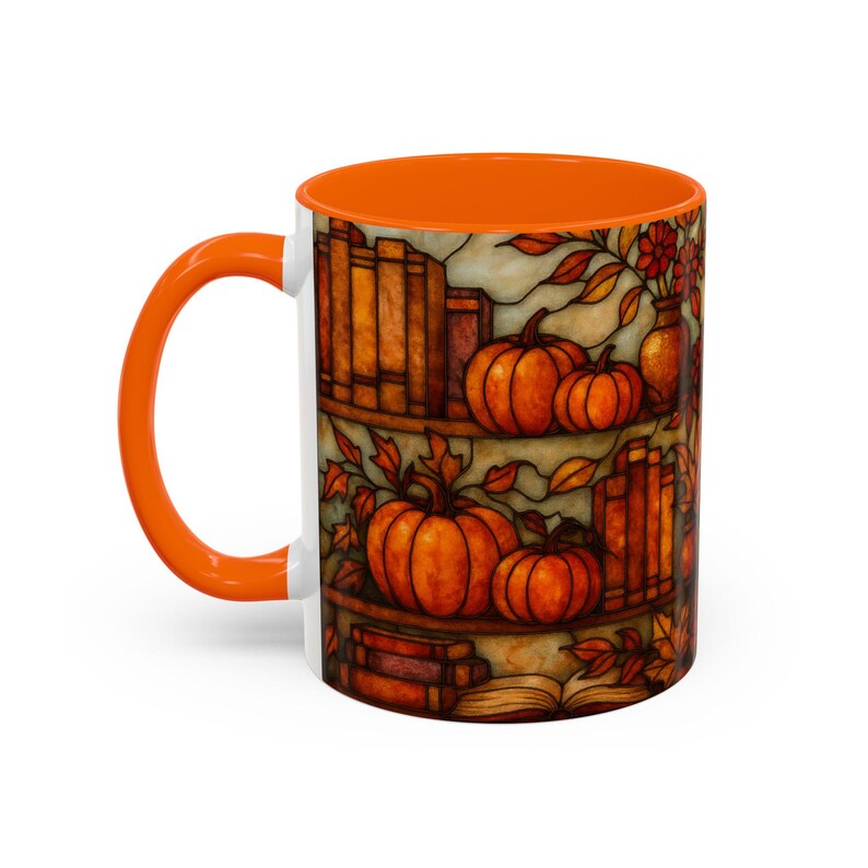 May include: White ceramic mug with an orange interior and handle. The mug features a fall-themed design with pumpkins, books, and autumn leaves. The design is in shades of orange, brown, and yellow.