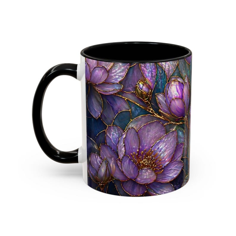 May include: A white ceramic mug with a black handle and interior. The mug features a floral design with purple flowers and gold outlines. The background is a dark blue color.