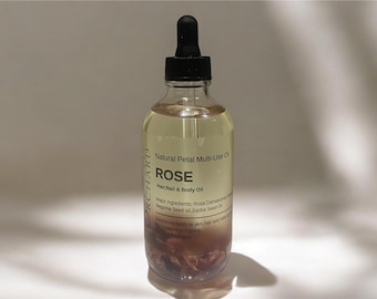 May include: A clear glass bottle with a black dropper top filled with a light yellow liquid. The bottle is labeled "Natural Petal Multi-Use Oil ROSE Hair, Nail & Body Oil" and contains dried rose petals.  Major ingredients: Rosa Damascena,  Begonia Seed Oil, Jojoba Seed Oil.