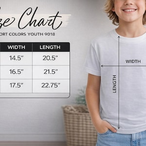 A young boy is standing next to a size chart, smiling and wearing a white t-shirt. The chart provides measurements for different shirt sizes, including S, M, L, and XL, along with corresponding widths and lengths.