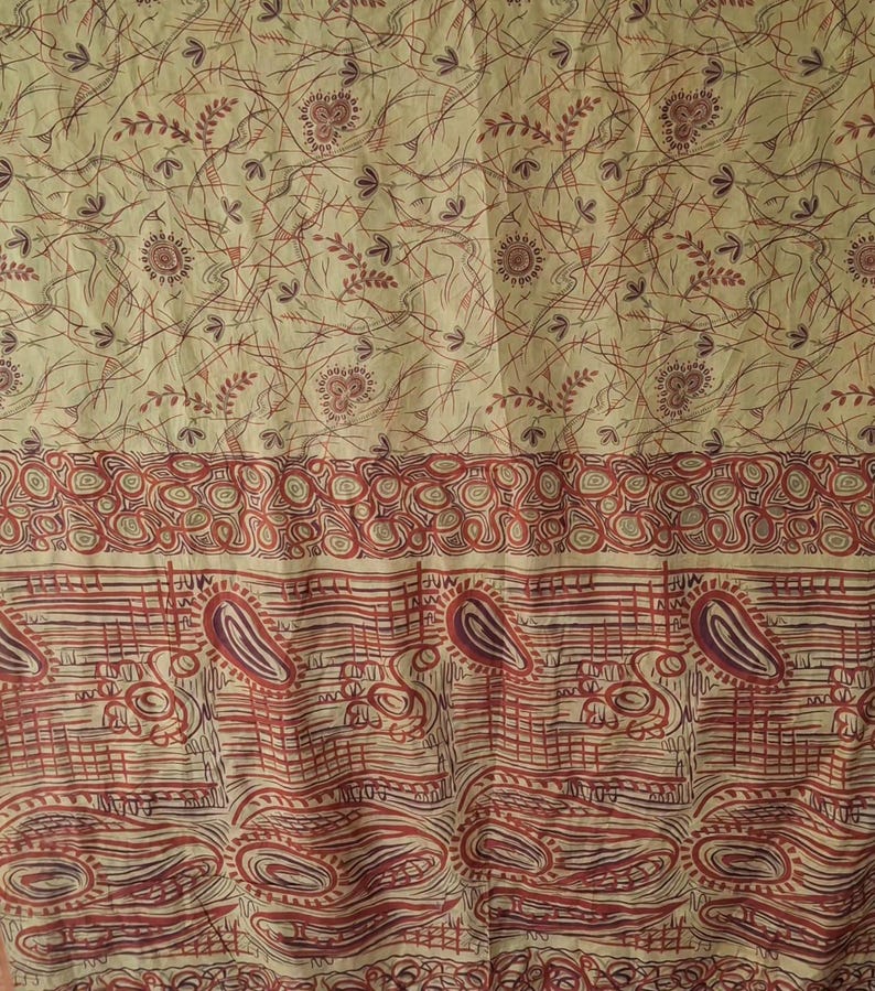 May include: A textile fabric featuring a cream-colored background with a dense pattern of thin, dark red and brown lines, small floral motifs, and circular shapes. A horizontal border displays repeating red paisley and abstract swirl designs.