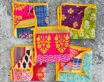 May include: Five colorful kantha quilts with yellow trim. The quilts are made of patchwork fabric and have a variety of floral and geometric patterns.