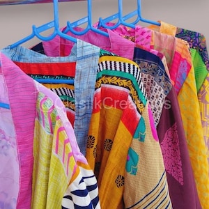 May include: A collection of colourful patterned fabric scarves hanging on blue plastic hangers. The scarves are made of different materials and have a variety of designs, including stripes, polka dots, and floral patterns.