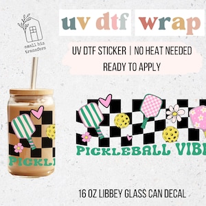 May include: A clear glass can with a bamboo lid and straw, featuring a pickleball-themed design. The design includes pickleball paddles, balls, flowers, and the words "Pickleball Vibes." The decal is designed for a 16 oz Libbey glass.