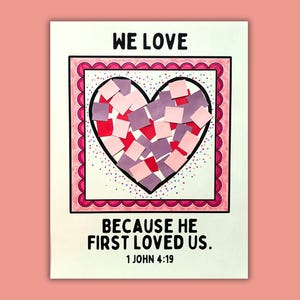 May include: A handmade card with a heart-shaped collage. The heart is filled with red and purple paper squares, framed by a pink border with a scalloped edge. The words "WE LOVE" and "BECAUSE HE FIRST LOVED US. 1 JOHN 4:19" are printed on the card.