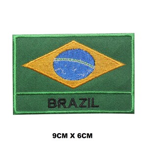 Puede incluir: Parche bordado verde, amarillo y azul con la palabra "BRAZIL" en letras negras. El parche mide 9 cm por 6 cm.