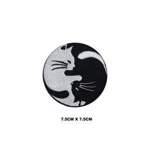 May include: Black and white embroidered patch of two cats in a yin yang design. The patch is 7.5 cm by 7.5 cm.