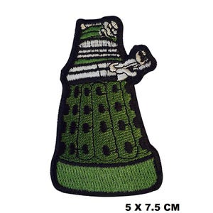 May include: Green and black embroidered iron-on patch of a Dalek, a fictional robot from the British science fiction television series Doctor Who. The patch is 5 inches by 7.5 inches.