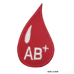 May include: Red blood drop embroidered patch with white lettering that says "AB+" and measures 6 cm by 3.5 cm.