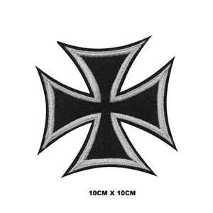 Może przedstawiać: Czarno-srebrna naszywka z żelaznym krzyżem o wymiarach 10 cm x 10 cm.