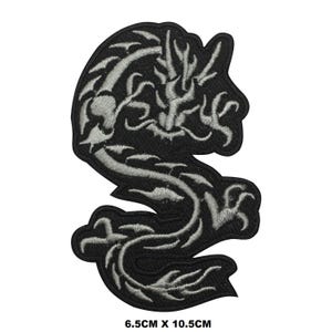 May include: Black and silver embroidered iron-on patch of a dragon with intricate details. The patch measures 6.5 cm by 10.5 cm.
